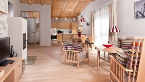Ein modernes Wohnzimmer mit Küche, Essbereich und Fernseher.