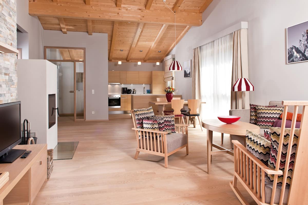 Ein modernes Wohnzimmer mit Küche, Essbereich und Fernseher.