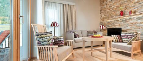 A modern living room with a wooden ceiling, a stone wall, a sofa, a rocking chair, and a television.