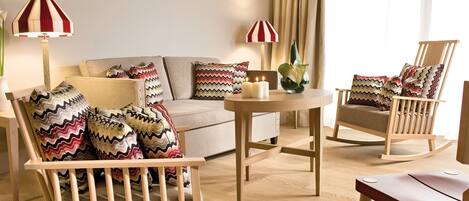 A living room with a sofa, two rocking chairs, a coffee table, and two lamps.