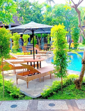 Una piscina al aire libre, sillones reclinables de piscina