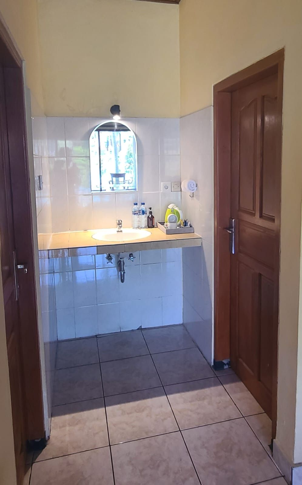 A small kitchen with a window, a sink, and a door.