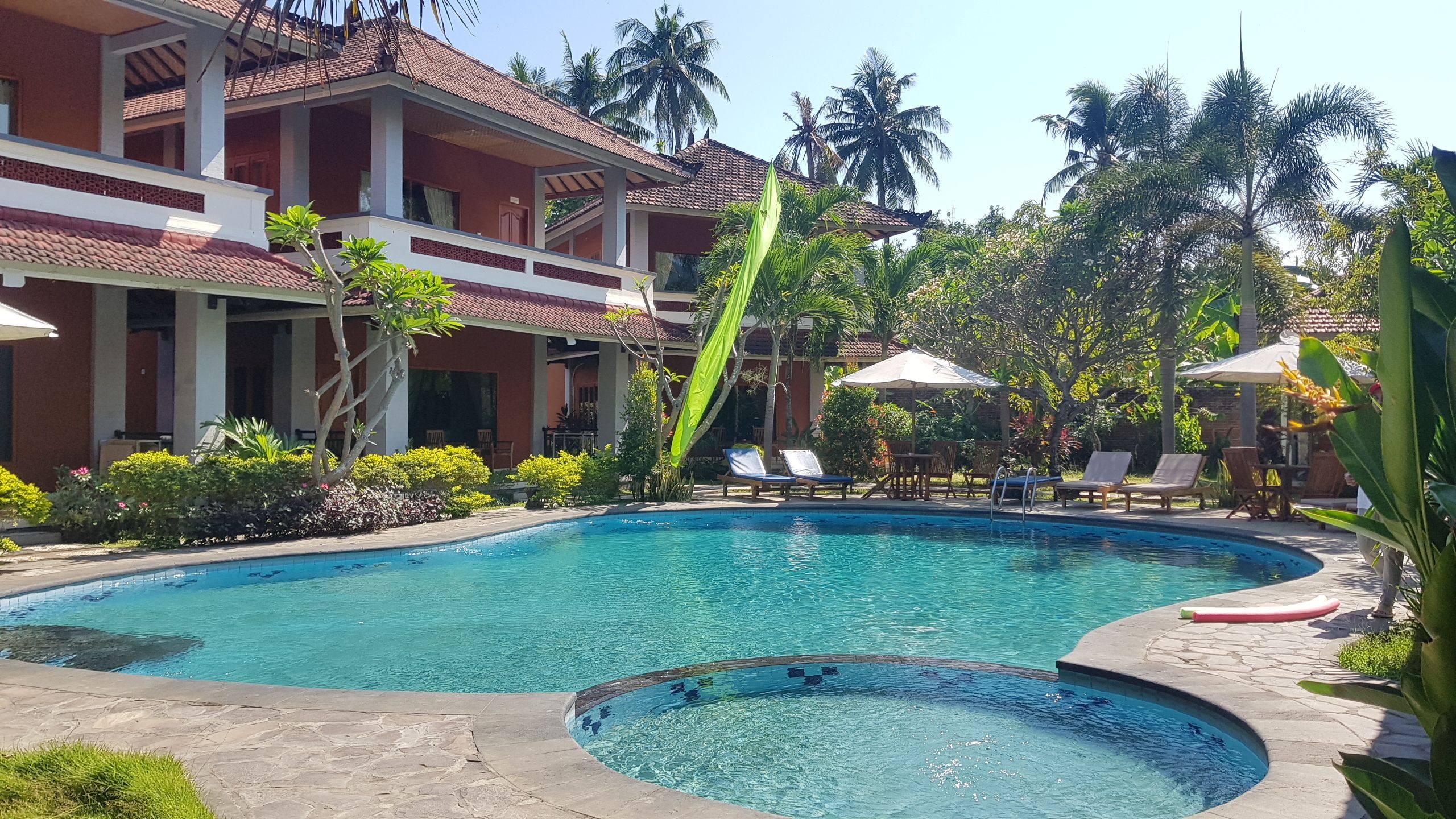 Una piscina al aire libre, sillones reclinables de piscina