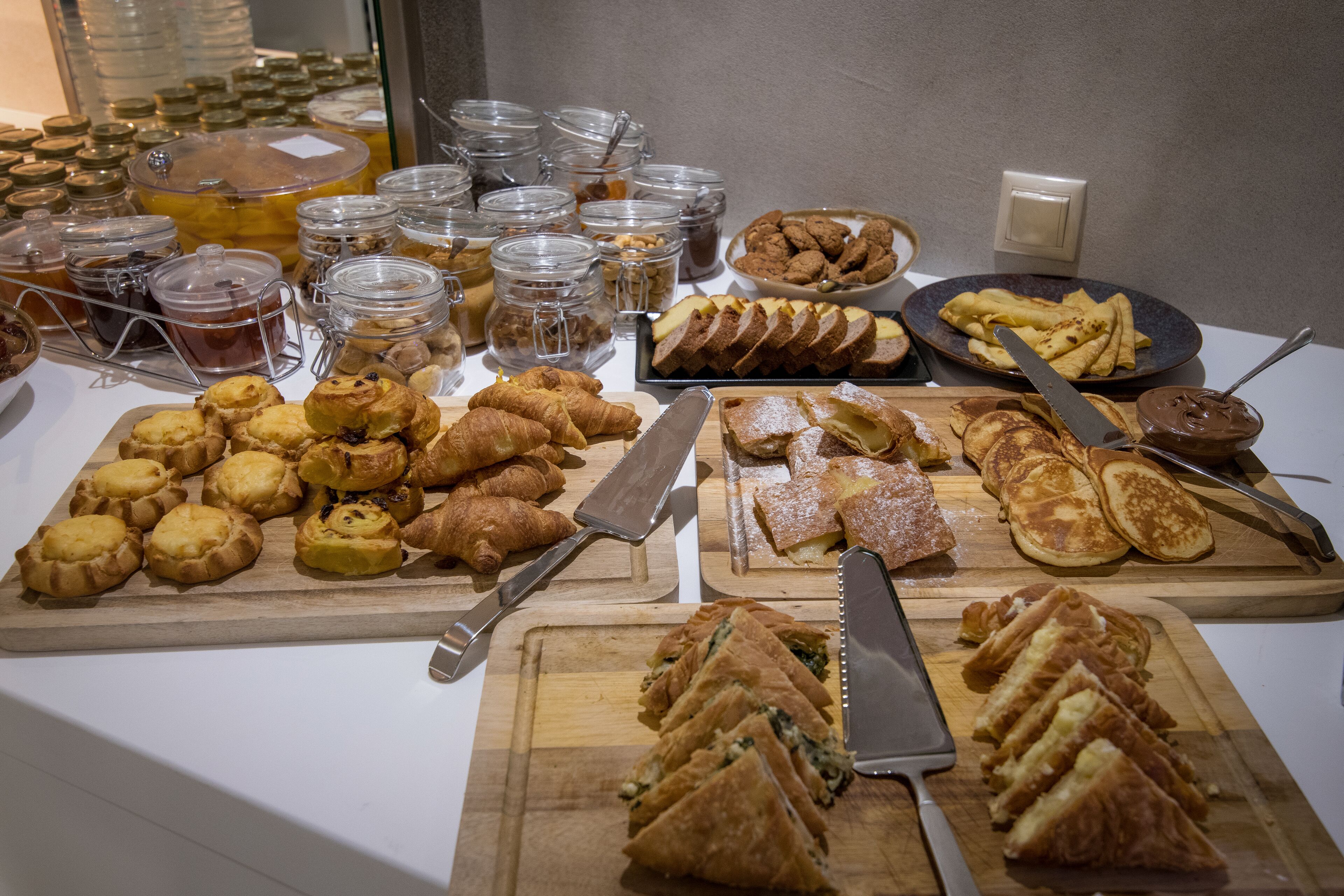 Un bufé con diversos pasteles, sándwiches y aderezos.