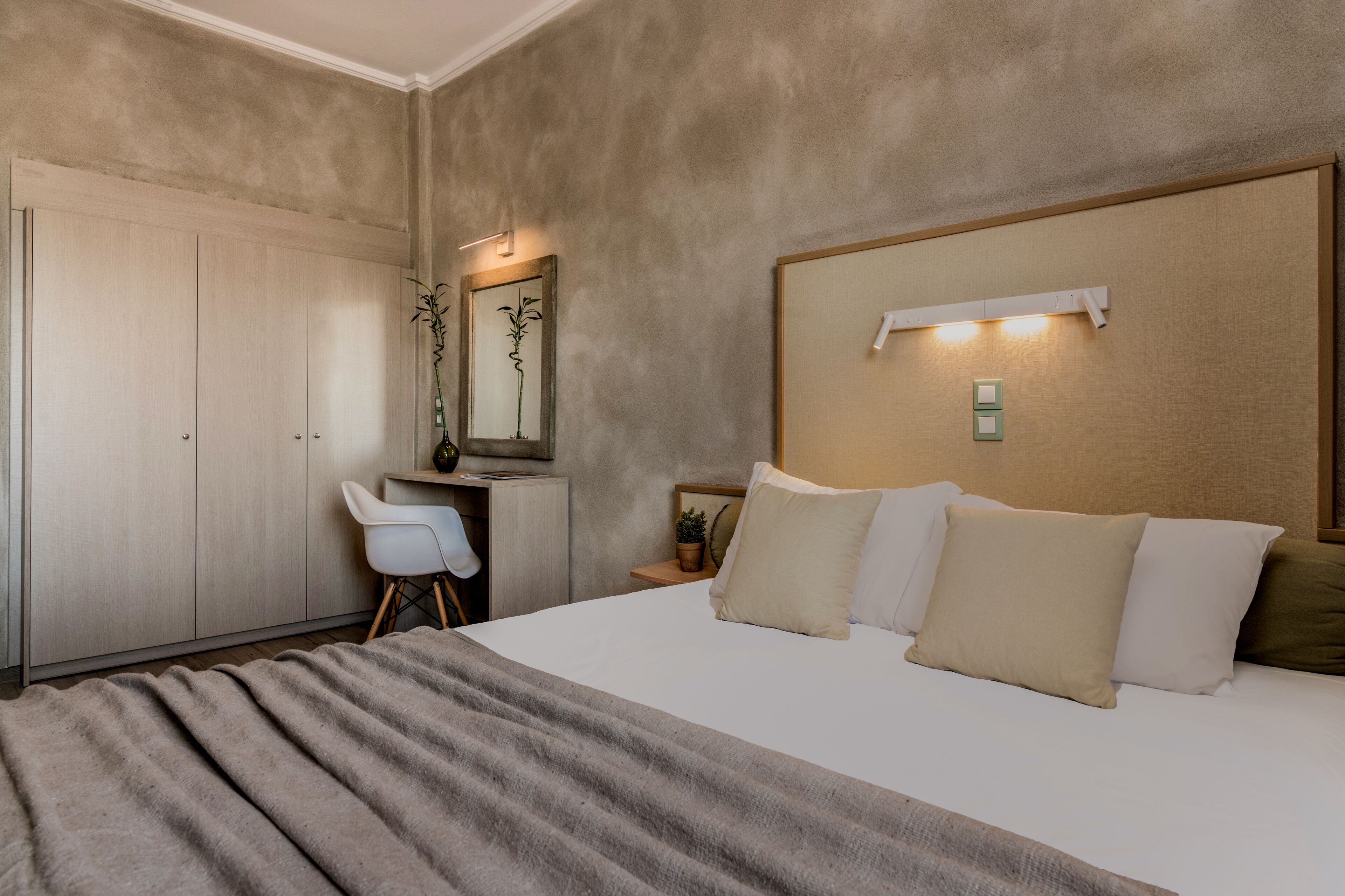 Ein Schlafzimmer mit einem Bett, einem Nachttisch, einer Lampe und einem Schreibtisch mit Stuhl.