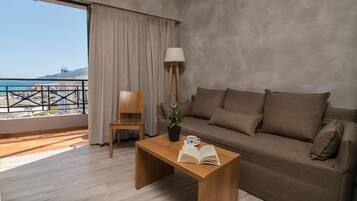 A modern living room with a balcony, a sofa, a wooden coffee table, a chair, a potted plant, and a lamp.