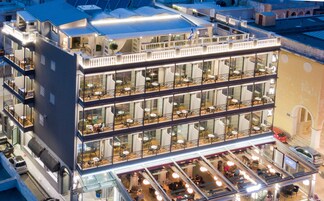 Un hotel de varios pisos con balcones, amplias ventanas y zonas de estar al aire libre.