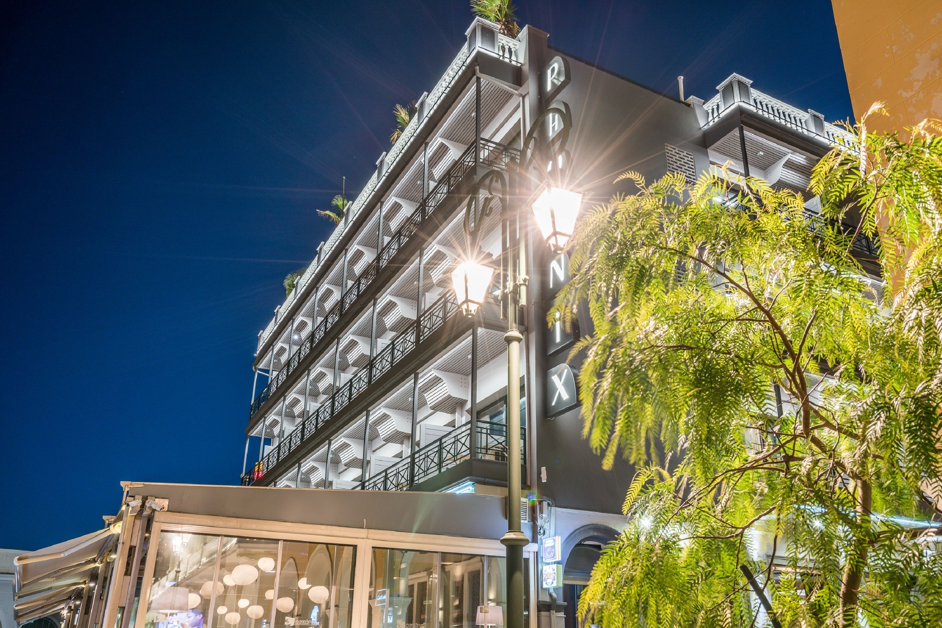 A multi-story building with balconies and a glass facade.