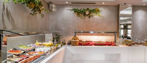 Una presentación de buffet moderna con diversos alimentos y una decoración floral.