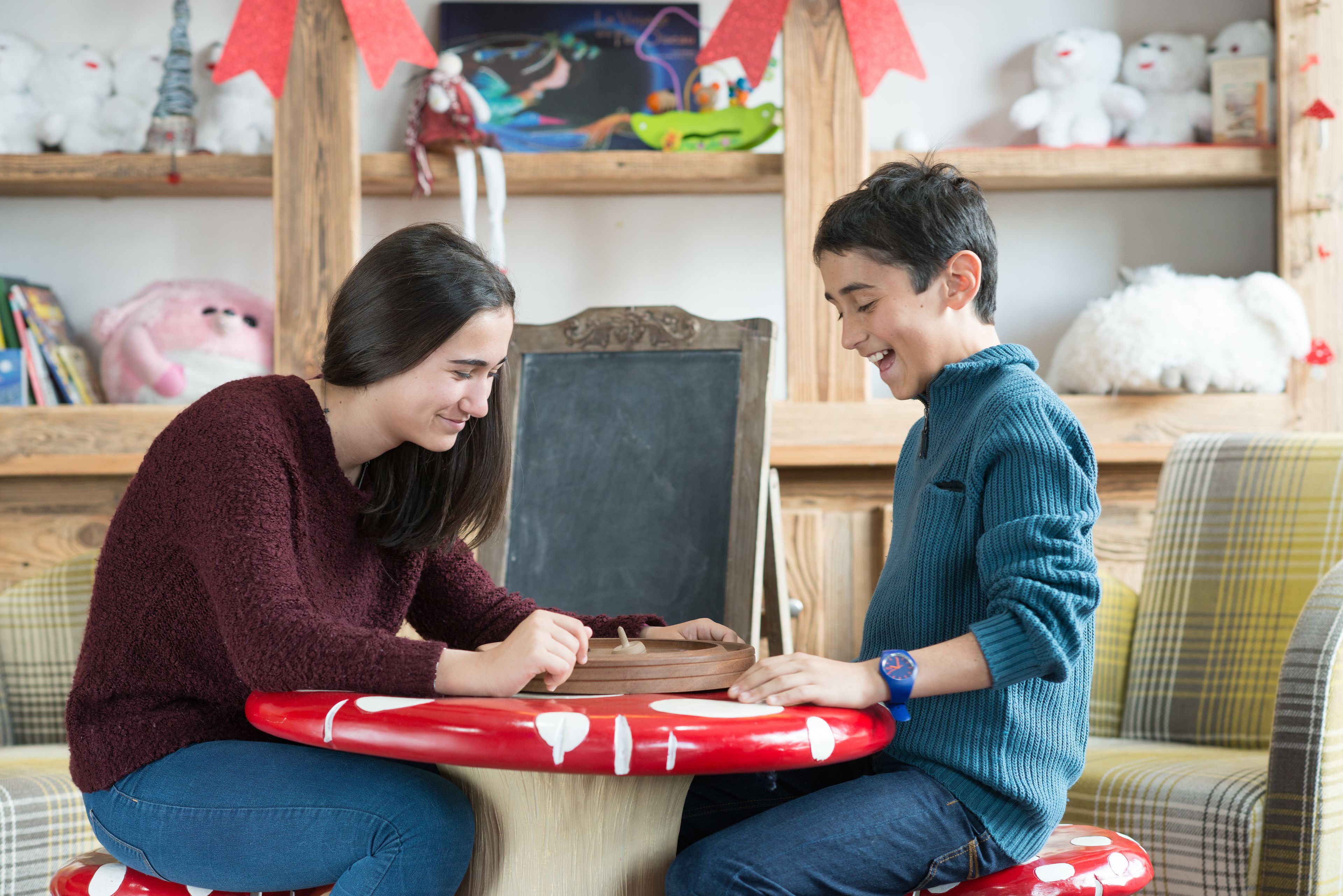 Two people sitting on a couch, playing a board game.