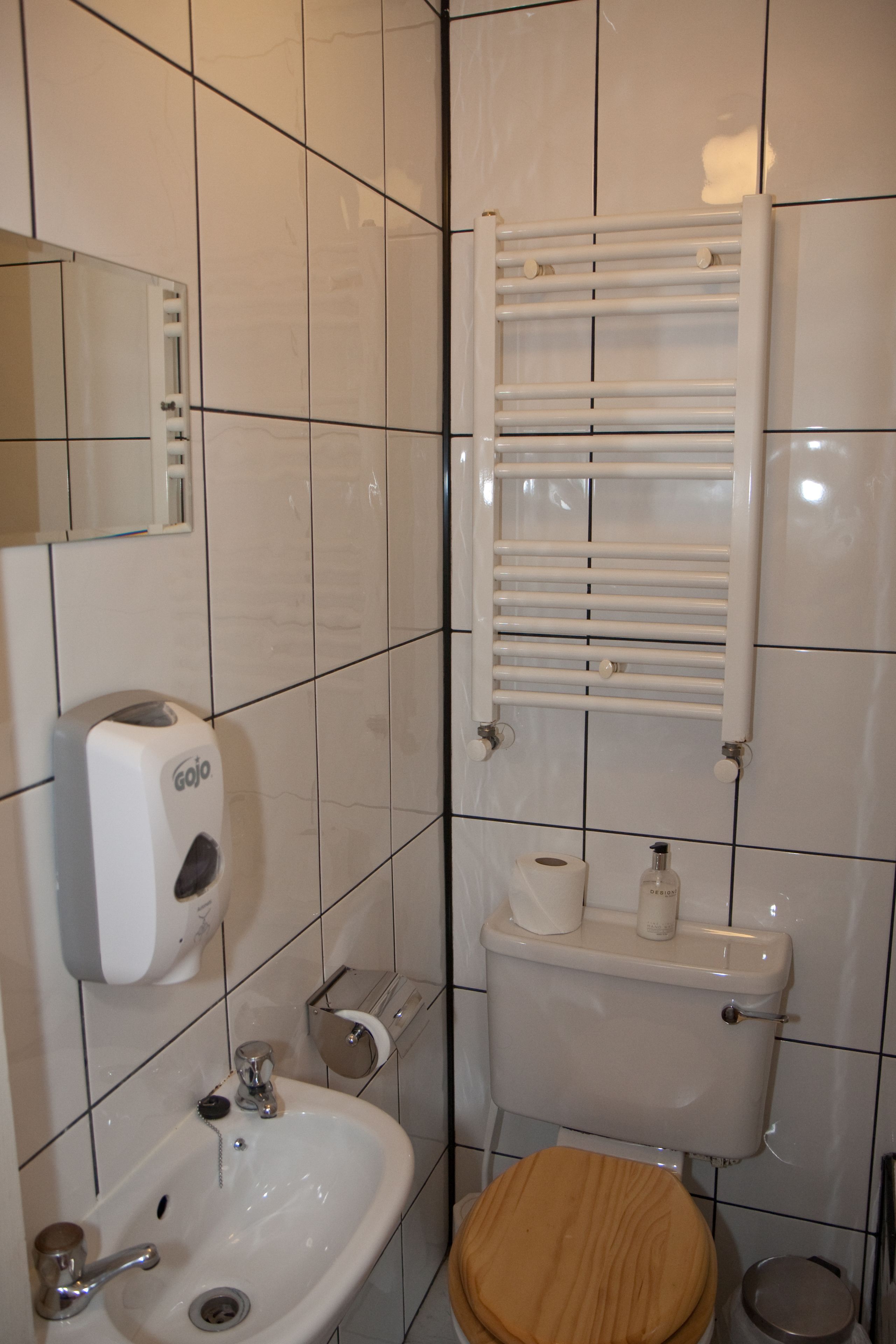 A bathroom with a toilet, sink, and hand dryer.