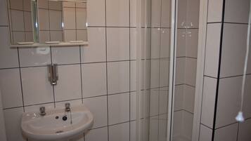 Une salle de bain avec un lavabo, un miroir et une douche.