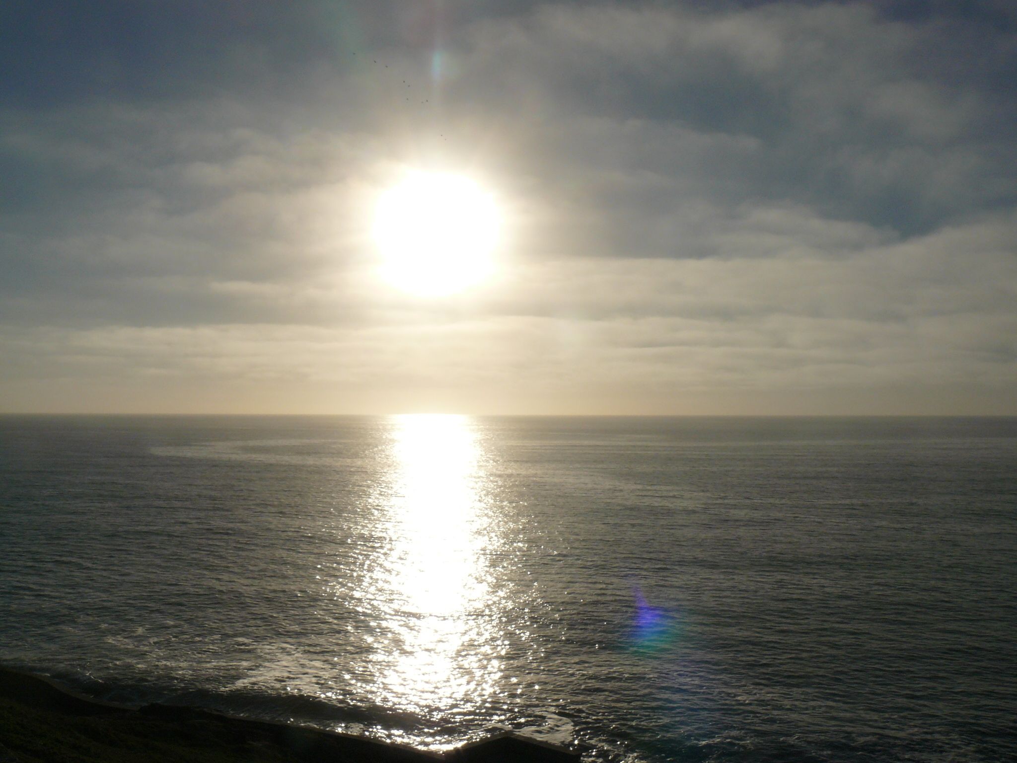 A sunset over a calm sea with a clear horizon.