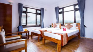 Ein Hotelzimmer mit zwei Holzbetten, einem Schreibtisch aus Holz und einem Stuhl.