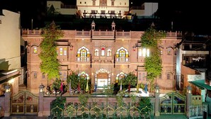A historic building with multiple stories, ornate windows, and a gated entrance. - Kuchaman Haveli (Jodhpur)