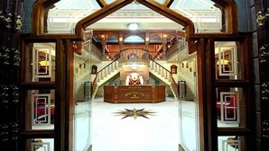 A grand reception area with a central desk, a staircase leading to an upper level, and a decorative star on the floor. - Kuchaman Haveli (Jodhpur)