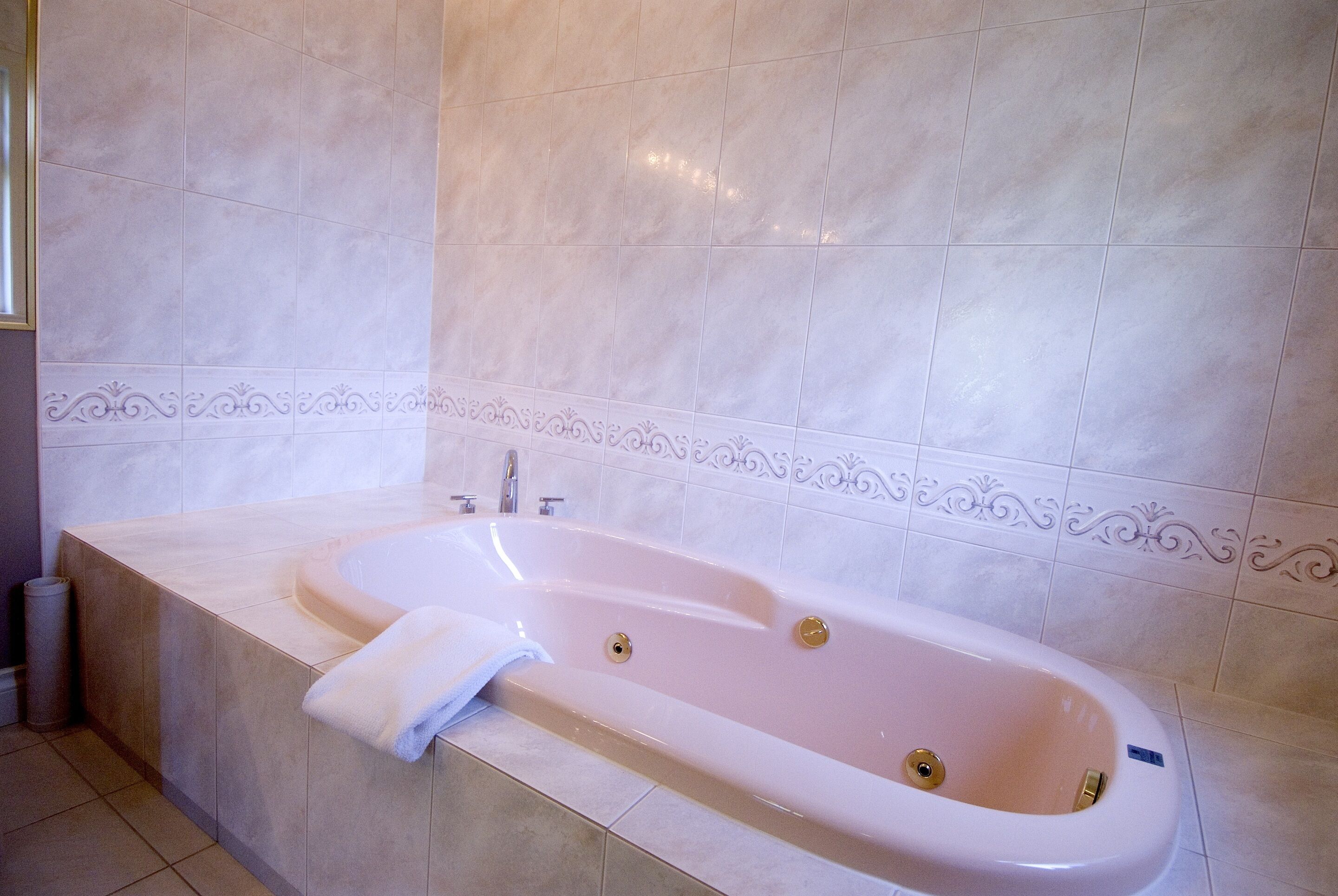 Ein Badezimmer mit freistehender Badewanne, einem Handtuch und einer Toilette.