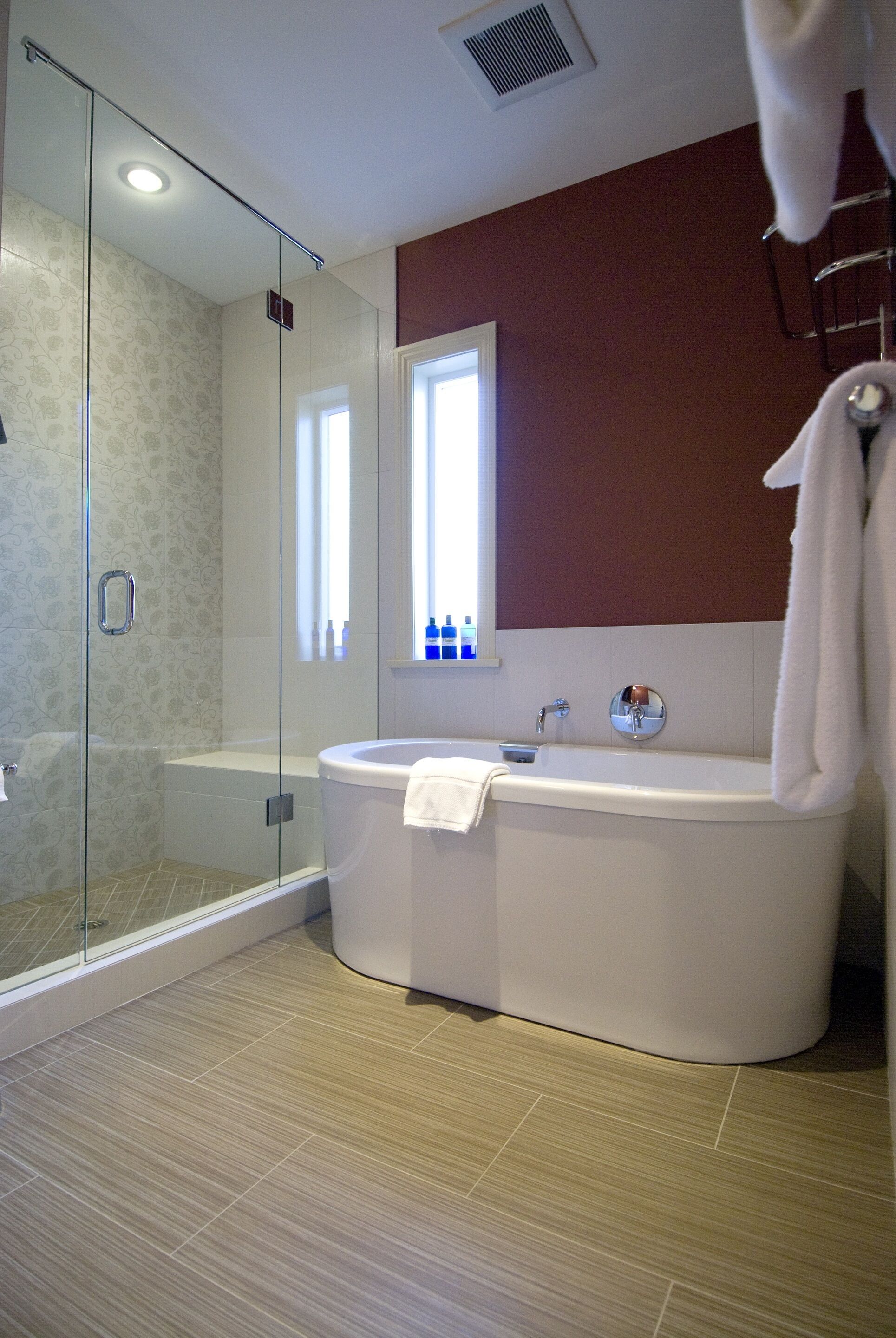 Une salle de bain moderne avec une douche à parois de verre, une baignoire sur pieds et un grand miroir.