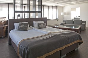 Une chambre d’hôtel moderne avec un grand lit, un canapé, une table basse et un bureau.