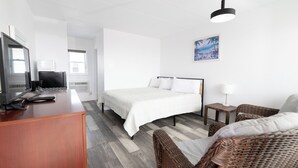 A hotel room with a bed, a desk with a computer, a chair, and a lamp. - Alante Oceanfront Motel (North Wildwood)
