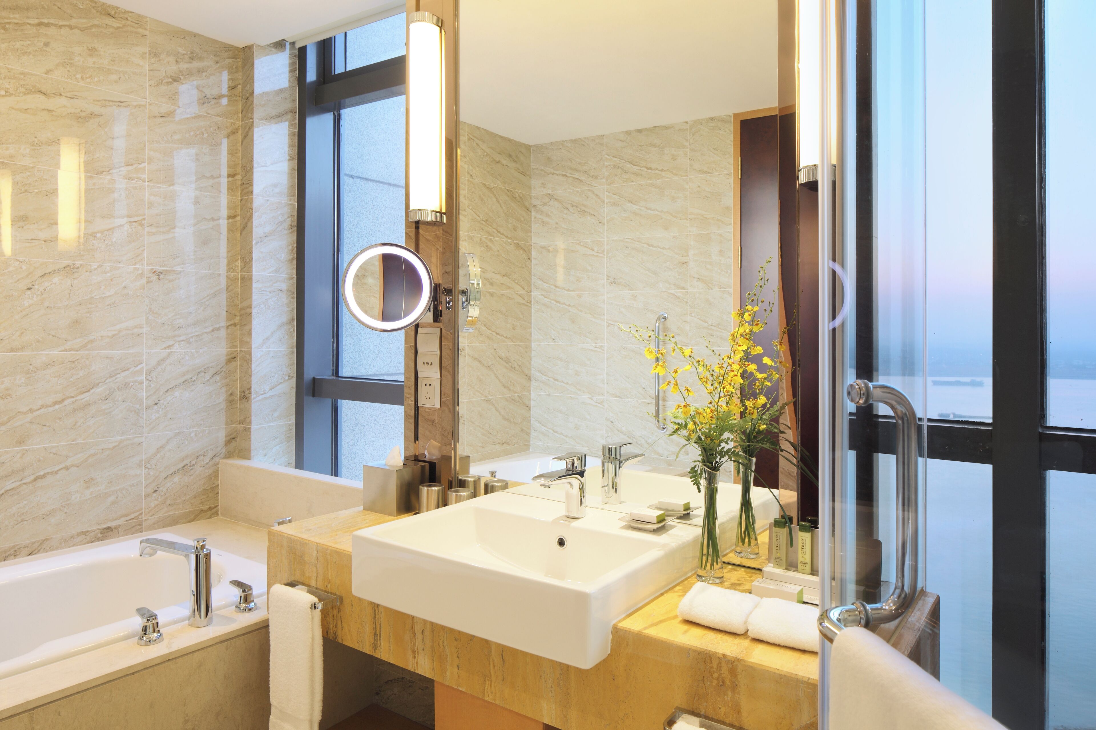Ein modernes Badezimmer mit einem großen Waschbecken, einer Badewanne und einer Duschkabine aus Glas.