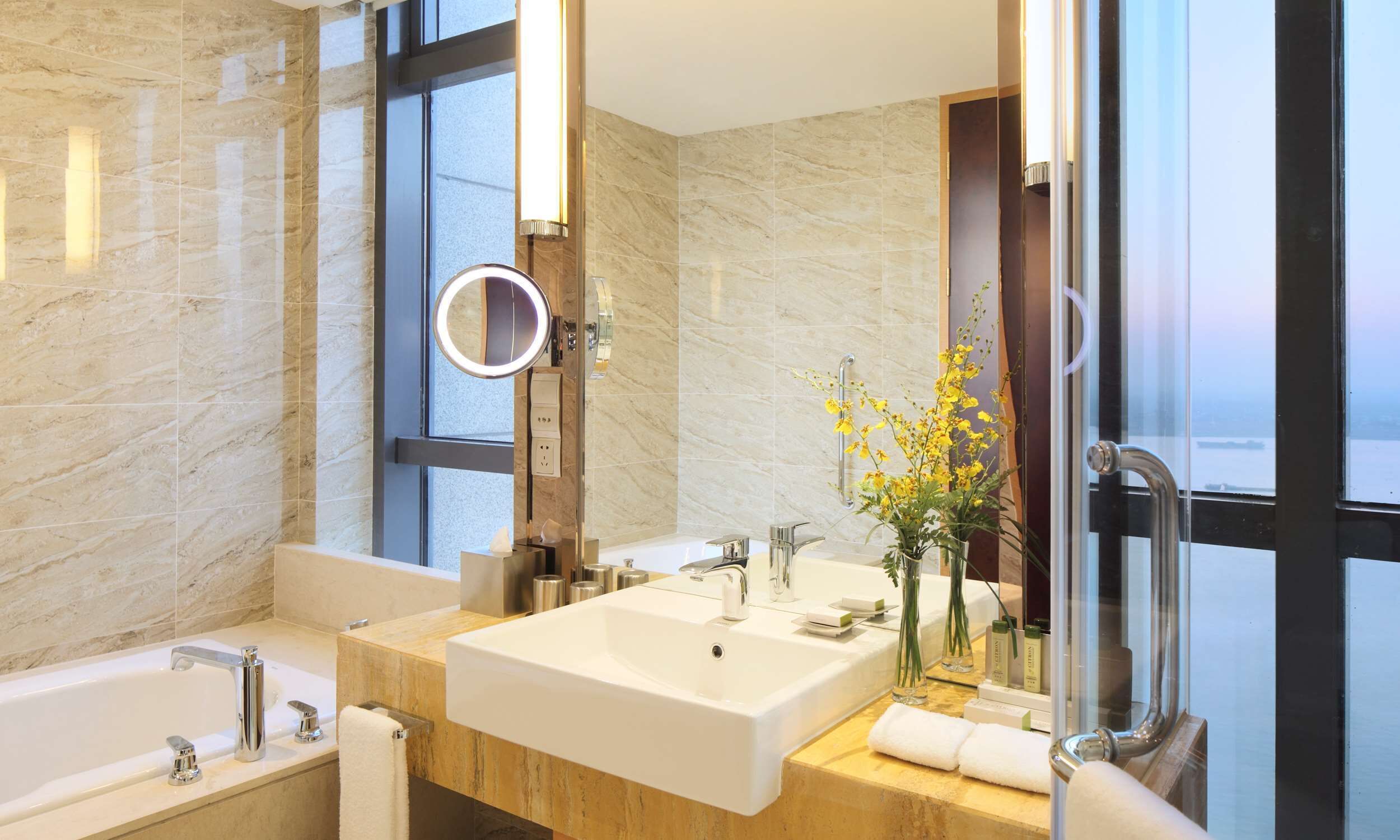 A modern bathroom with a large sink, a bathtub, and a glass shower enclosure.