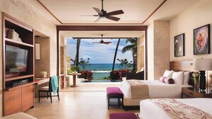 A hotel room with a large bed, a TV, a desk, and a view of the ocean. - Residences at Dorado Beach, a Ritz-Carlton Reserve (Dorado)