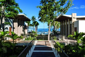 A resort with a wooden deck leading to a beach view, surrounded by palm trees and modern architecture. - Residences at Dorado Beach, a Ritz-Carlton Reserve (Dorado)