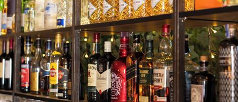 A bar area with shelves of liquor bottles and rows of glasses.
