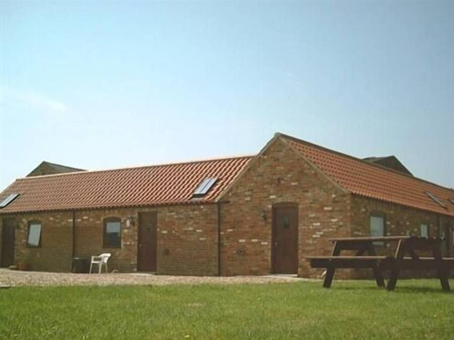 A brick building with a sloped roof, a door, and a window.