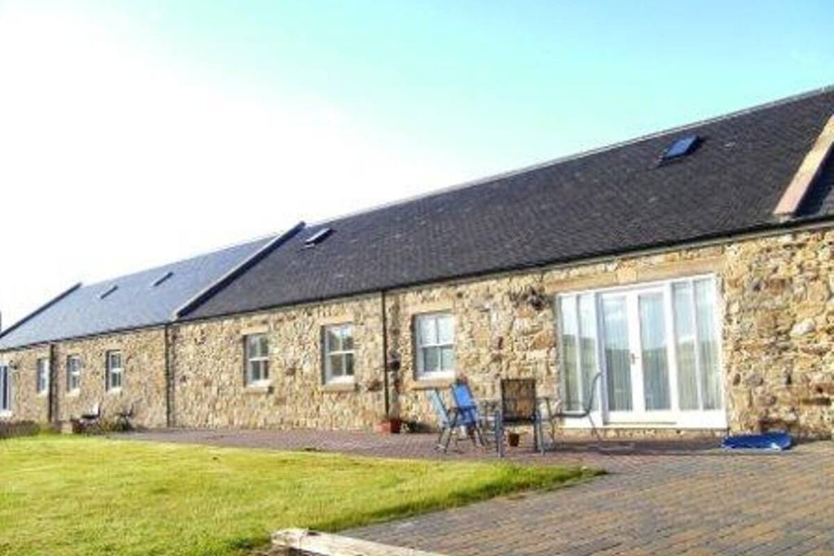 A stone building with a flat roof and large windows.