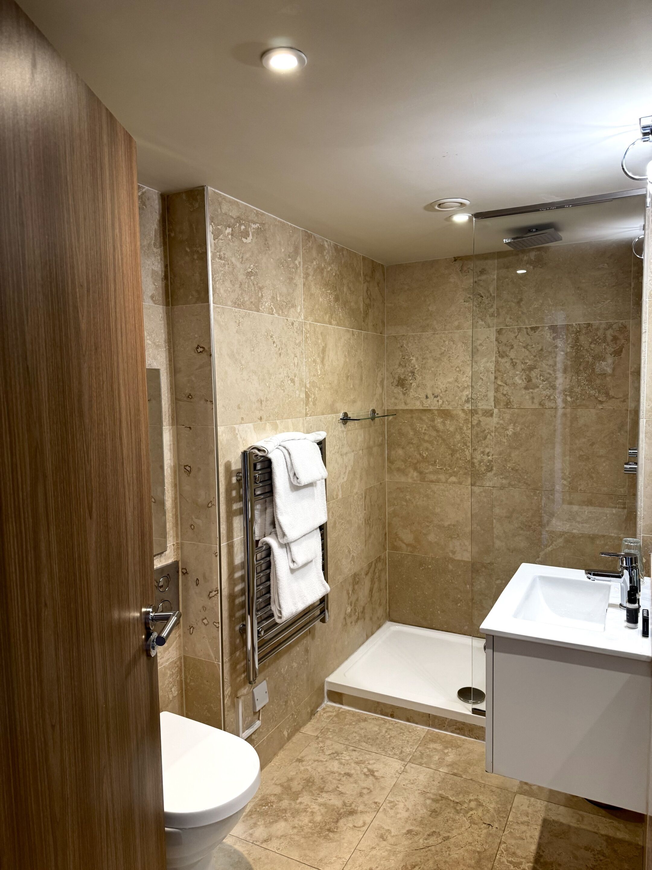 A modern bathroom with a shower, toilet, and sink.