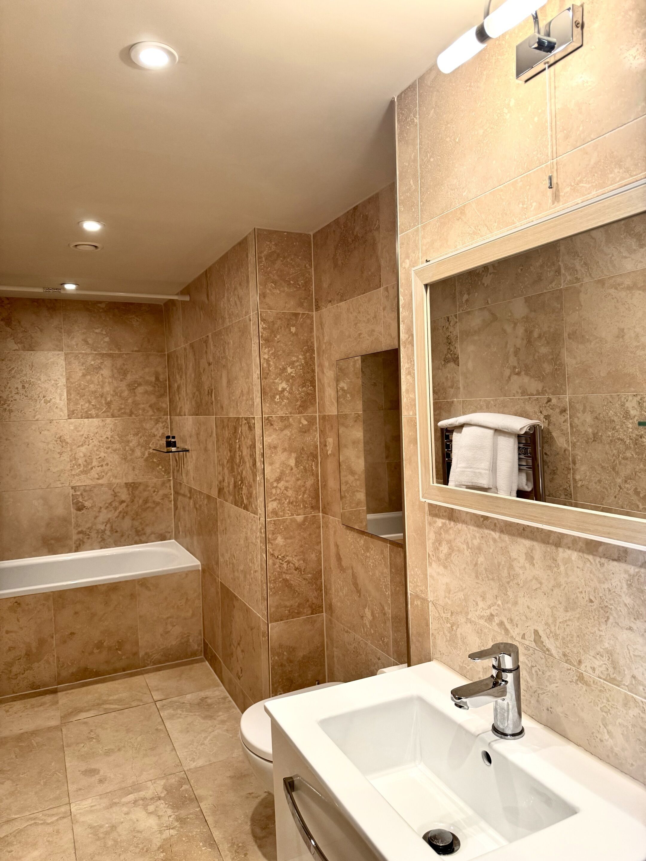 A modern bathroom with a bathtub, a sink, and a toilet.