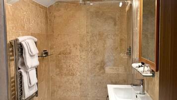 A modern bathroom with a shower, a sink, and a toilet.