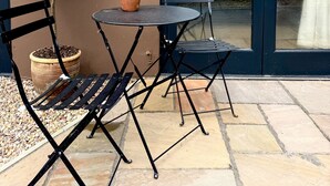 A patio with a table and chairs, a potted plant, and a door with a number 10 on it. - Top Joes Townhouse (Narberth)