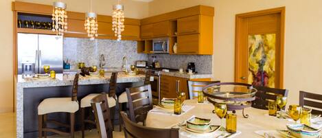 A modern kitchen with granite countertops, wooden cabinets, and a central island with seating.
