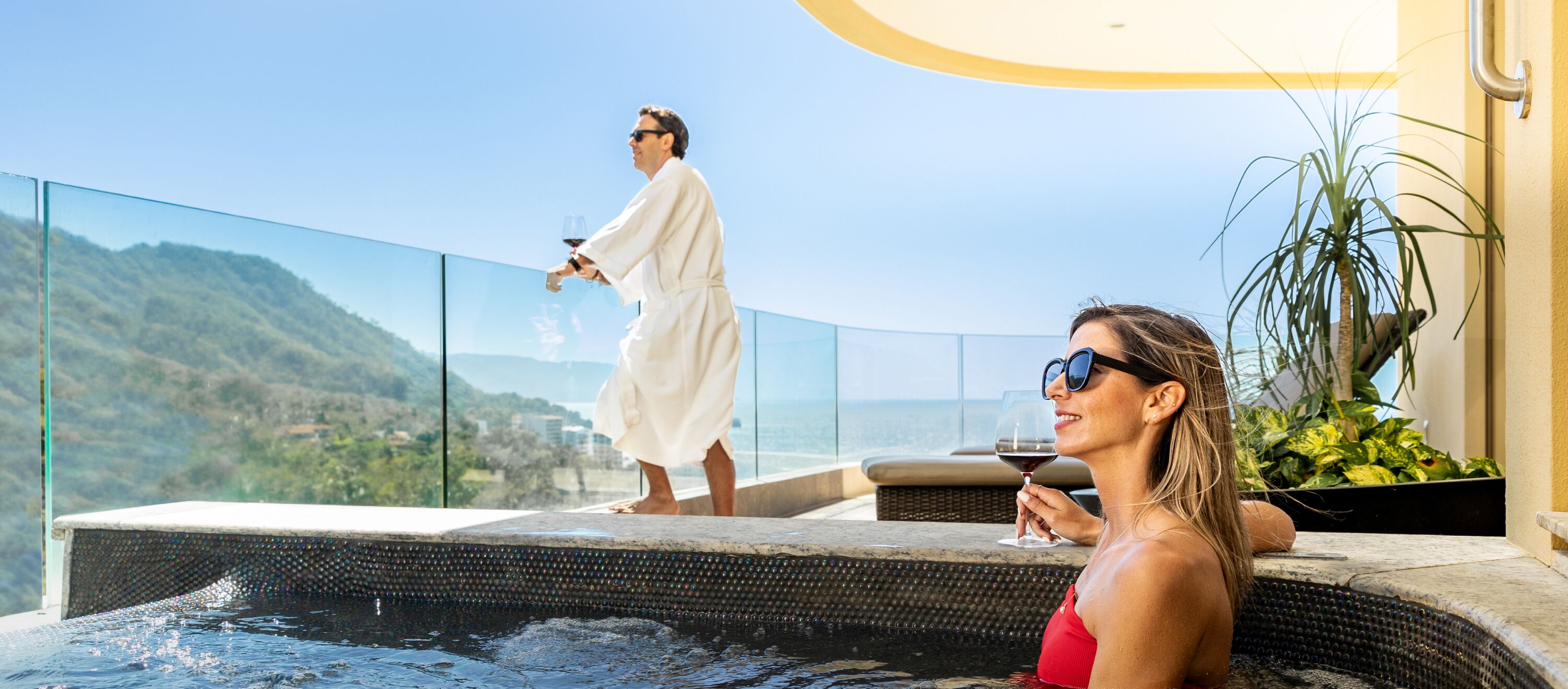 A couple relaxing by a pool with a scenic mountain view.
