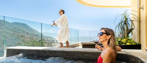 A couple relaxing by a pool with a scenic mountain view.