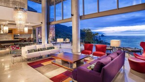 Amplia sala de estar con un gran ventanal con vistas panorámicas, una lámpara moderna y muebles contemporáneos.