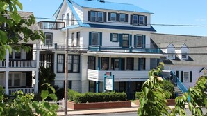 A two-story hotel with a blue roof and white walls, featuring a balcony and a sign indicating it is a hotel. - Surf Villa Hotel (Ocean City)