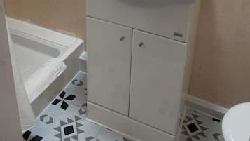 A bathroom with a white sink, a mirror, and a toilet.