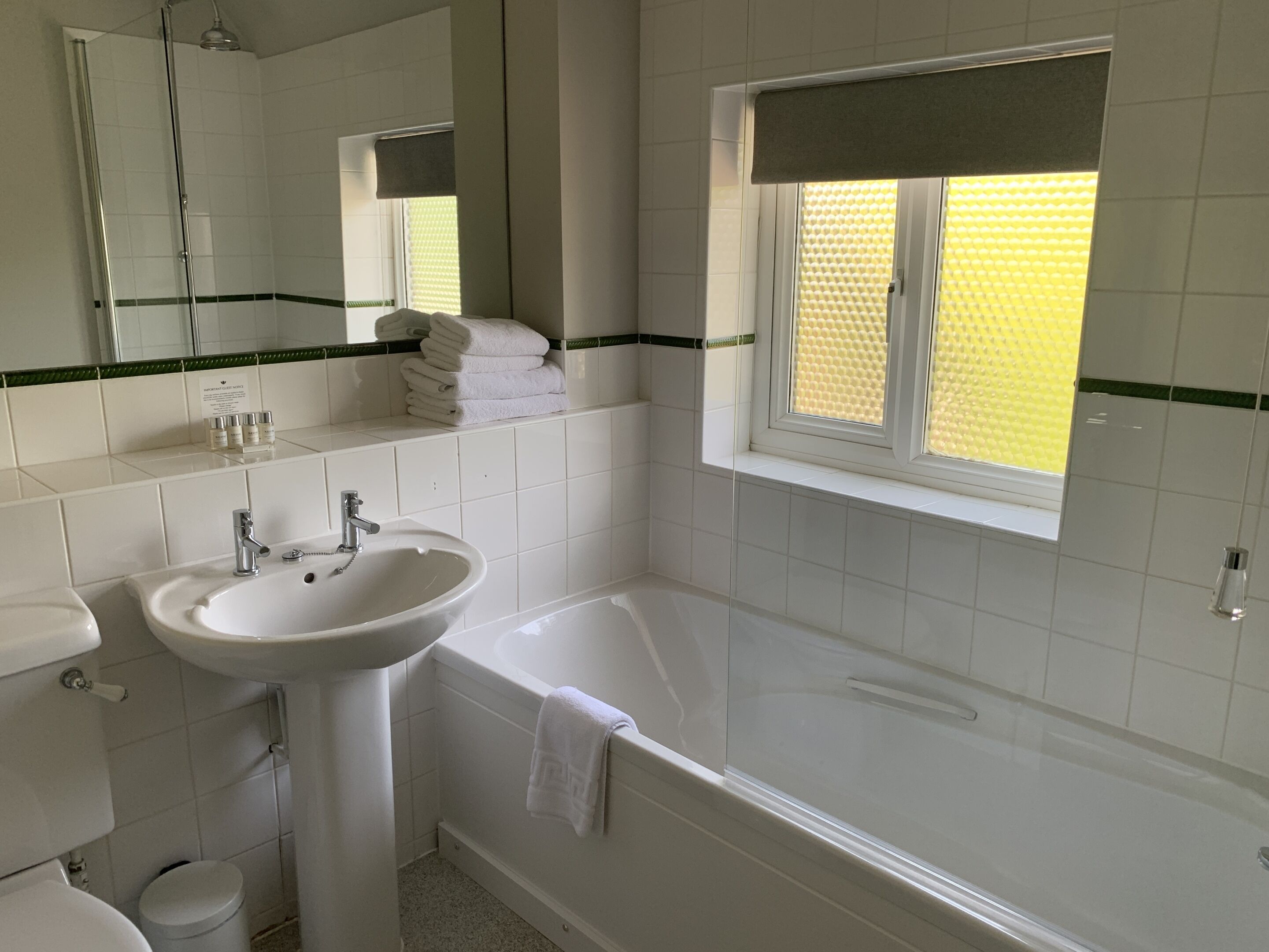 A bathroom with a sink, mirror, and bathtub.