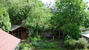 A garden with a wooden structure, a lawn, and various plants.