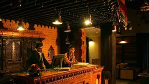 A traditional interior with a brick wall, a wooden counter, and hanging lights. - Hotel Heritage (Bhaktapur)