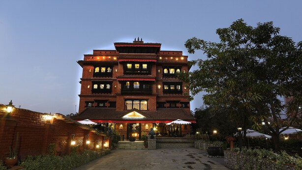 A multi-story building with a traditional architectural style, featuring a central entrance with steps and a covered area. - Hotel Heritage (Bhaktapur)