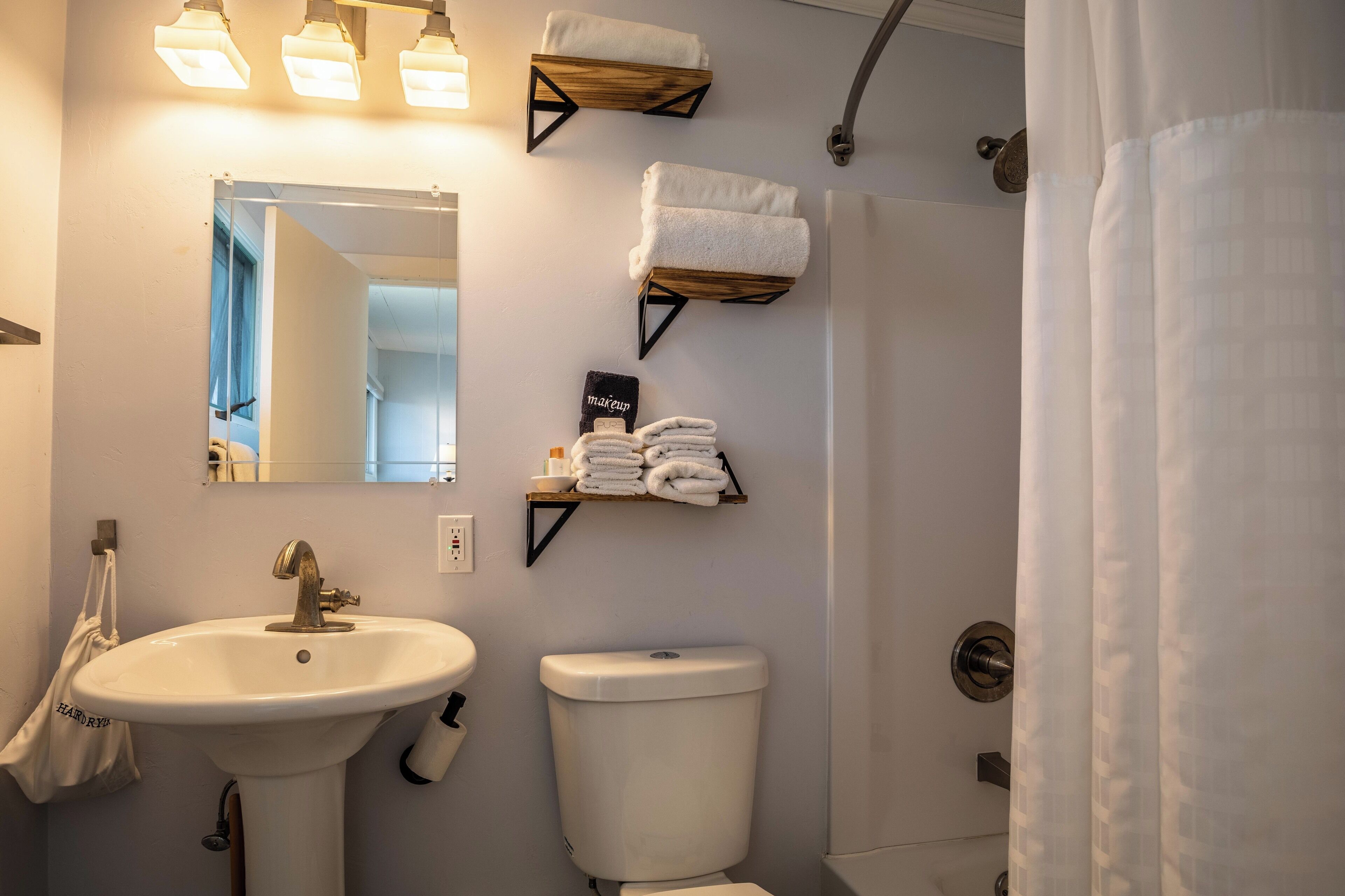 Une salle de bain équipée d’un lavabo, de toilettes et de porte-serviettes.