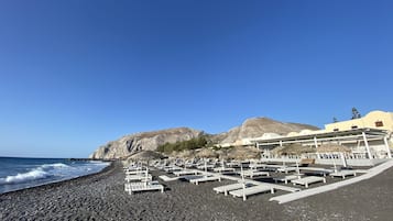 Plage, sable noir, chaises longues, parasols
