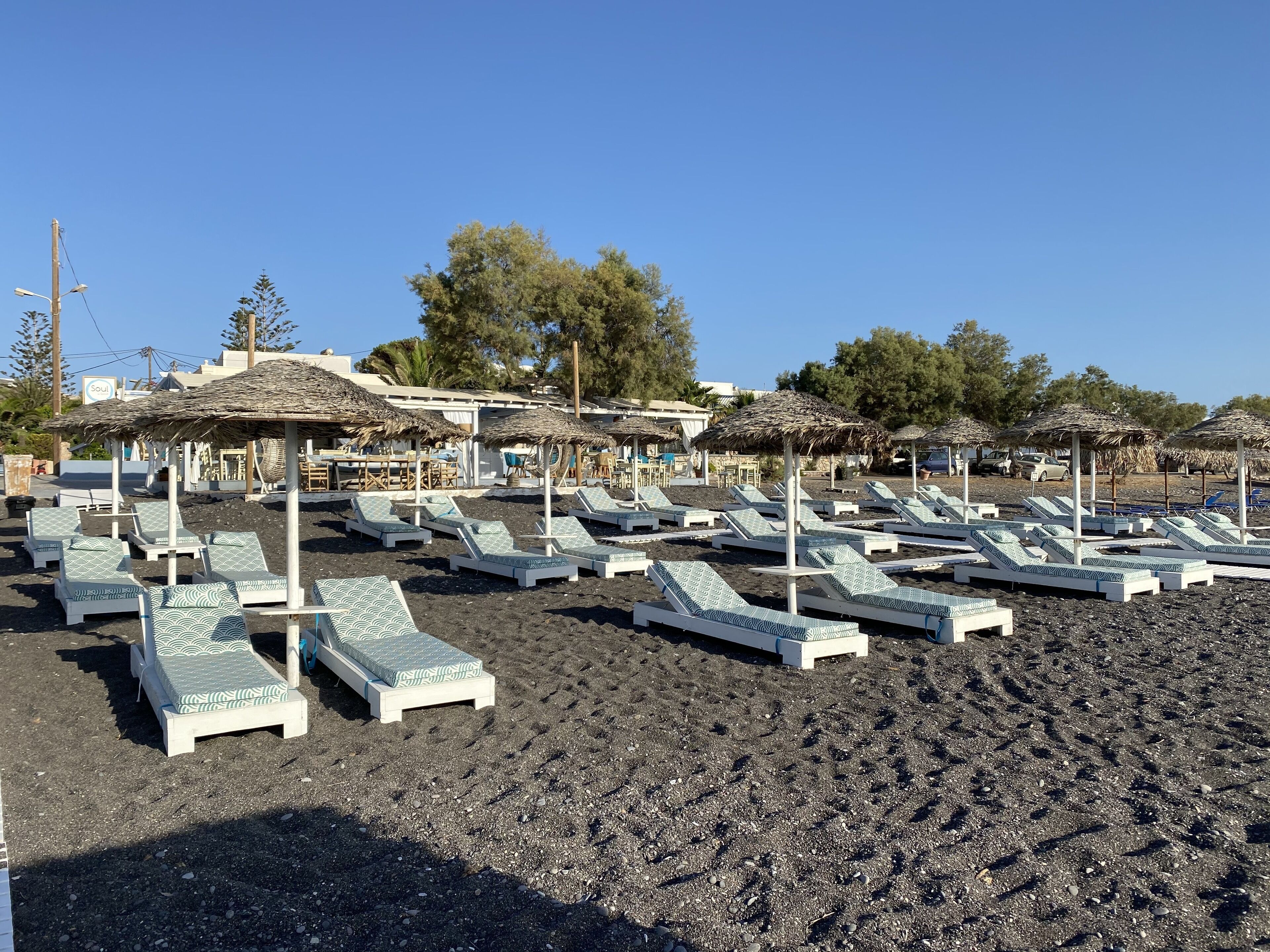 on the beach, black sand, sun-loungers, beach umbrellas
