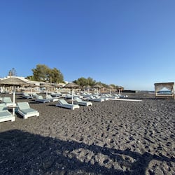 On the beach, black sand, sun-loungers, beach umbrellas