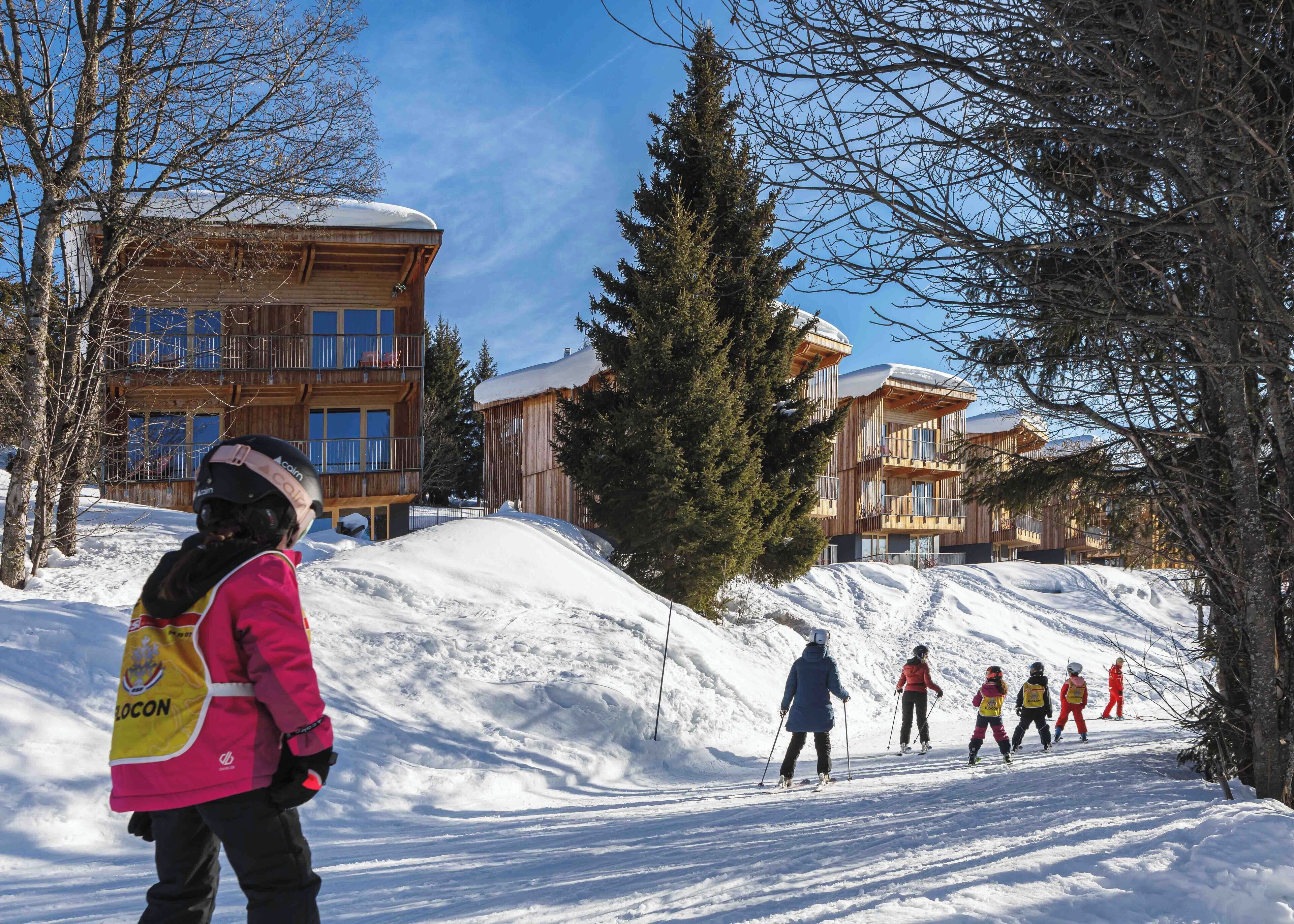 A ski resort with wooden buildings and snow-covered slopes.